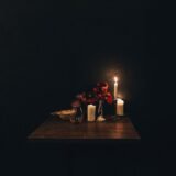 Lanternă aprinsă și o lampă mică pe masa din bucătărie, în timpul unei pene de curent seara